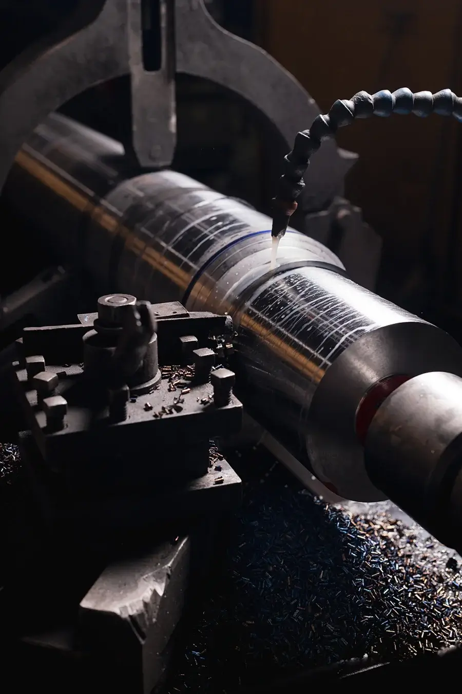 Metal cylinder being precisely machined on industrial lathe.