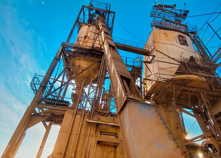 Industrial equipment towering under a clear blue sky.