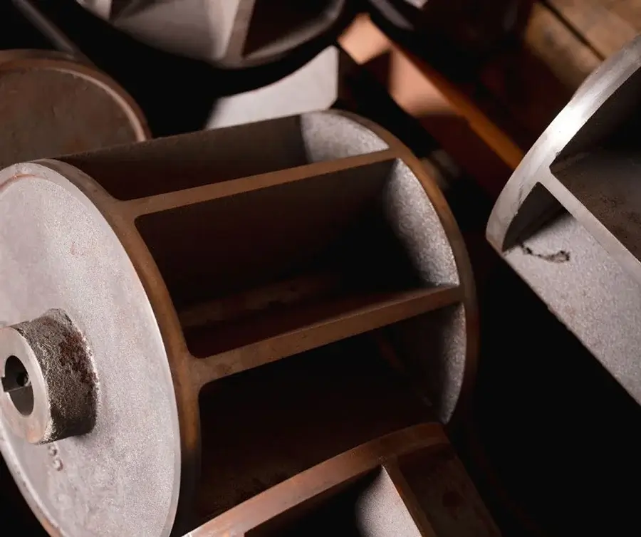 Industrial fan blades stacked in dim warehouse lighting.