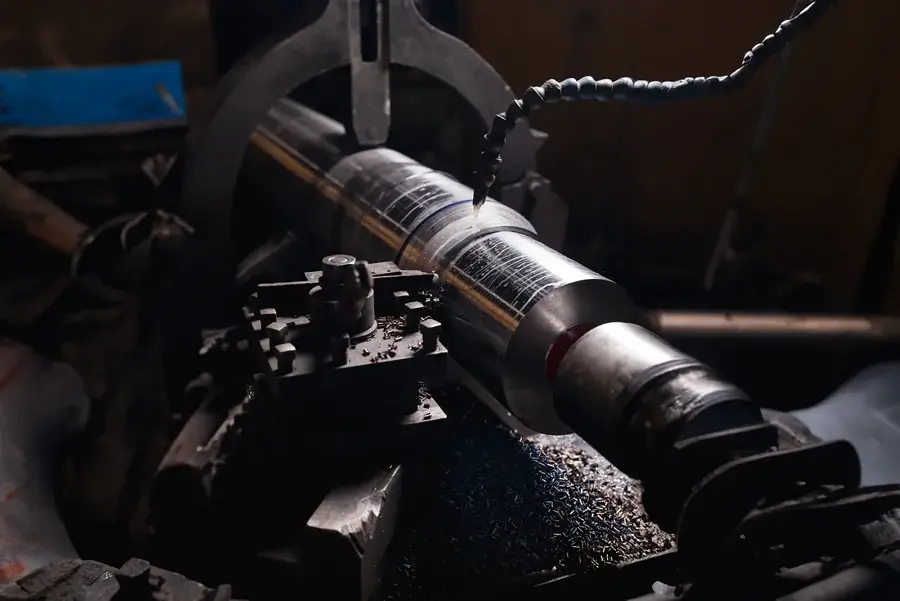 Metal lathe machining a rotating cylindrical part.
