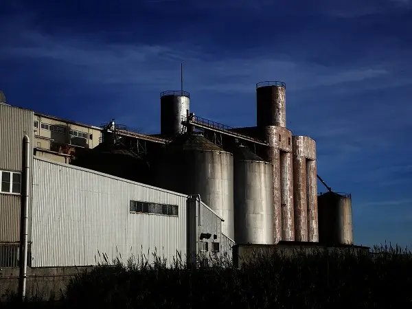 Industrial plant with large cylindrical storage silos.