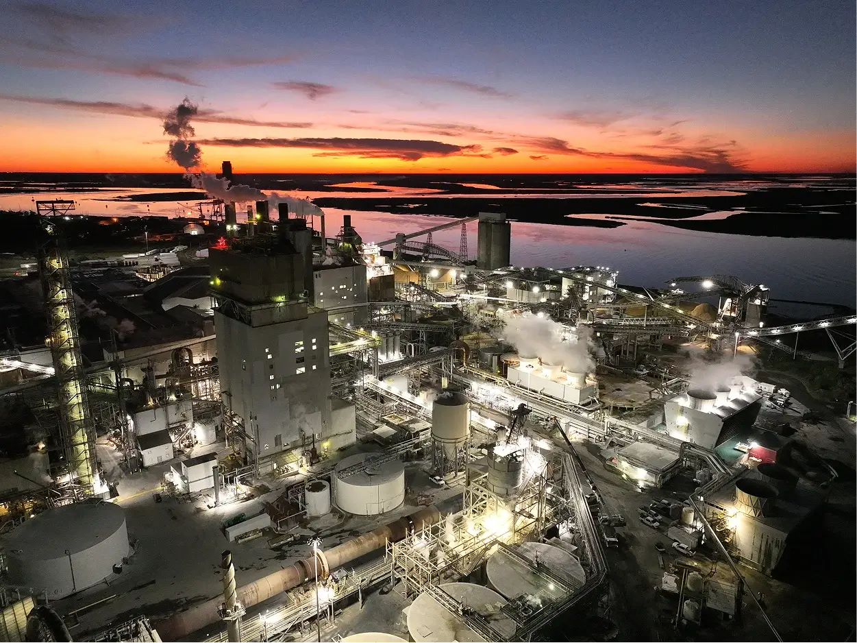 Industrial plant operating at dusk with vibrant sunset.