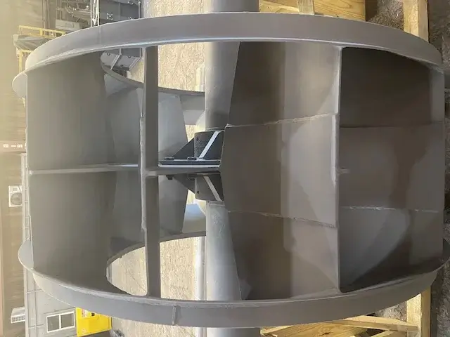 Large industrial fan displayed on wooden platform.