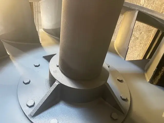 Industrial fan blades with sunlight illuminating surface.