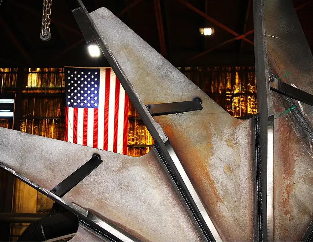 Industrial fan blades with American flag background.