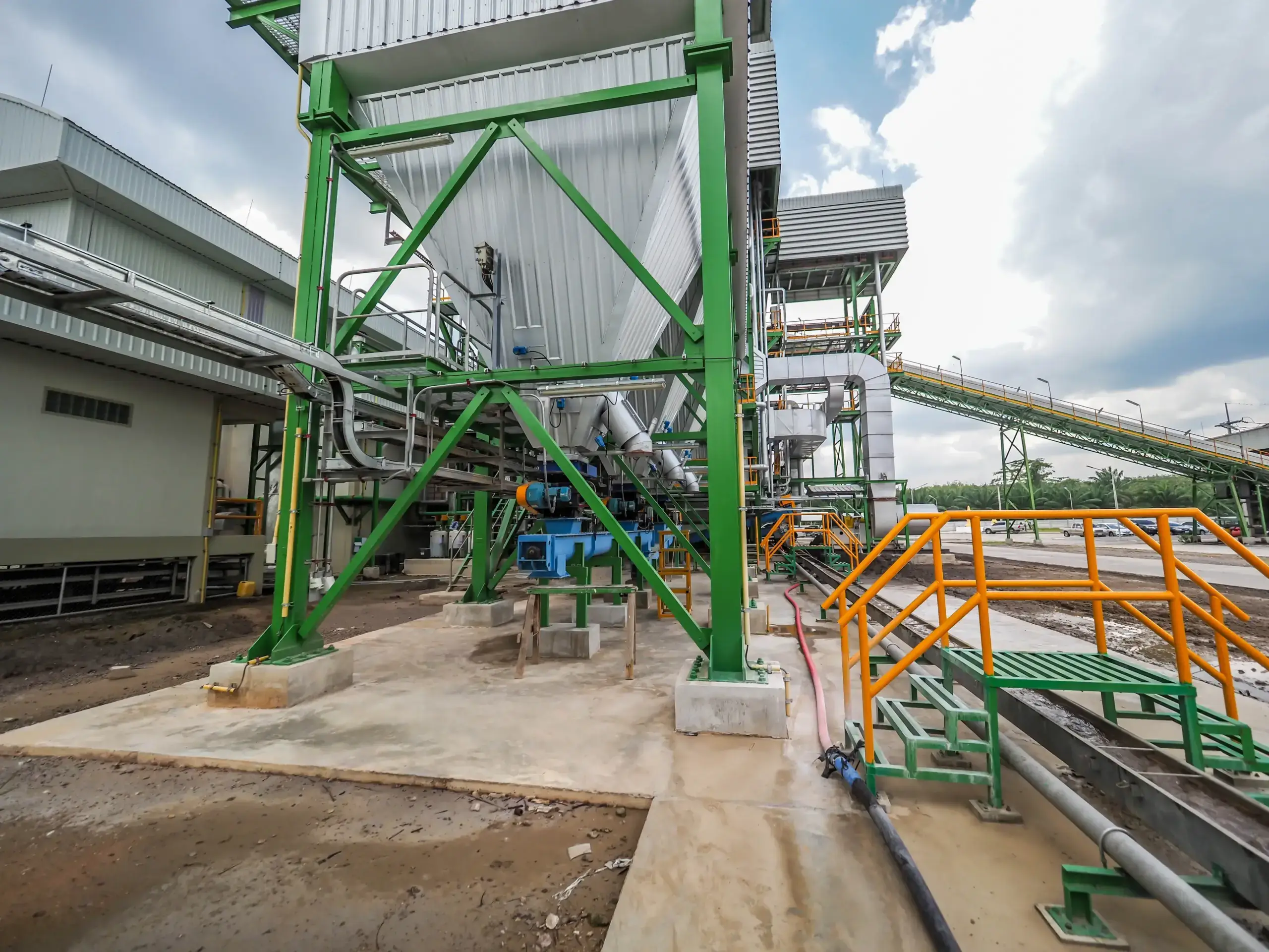 Industrial facility with pipes and green steel structures.