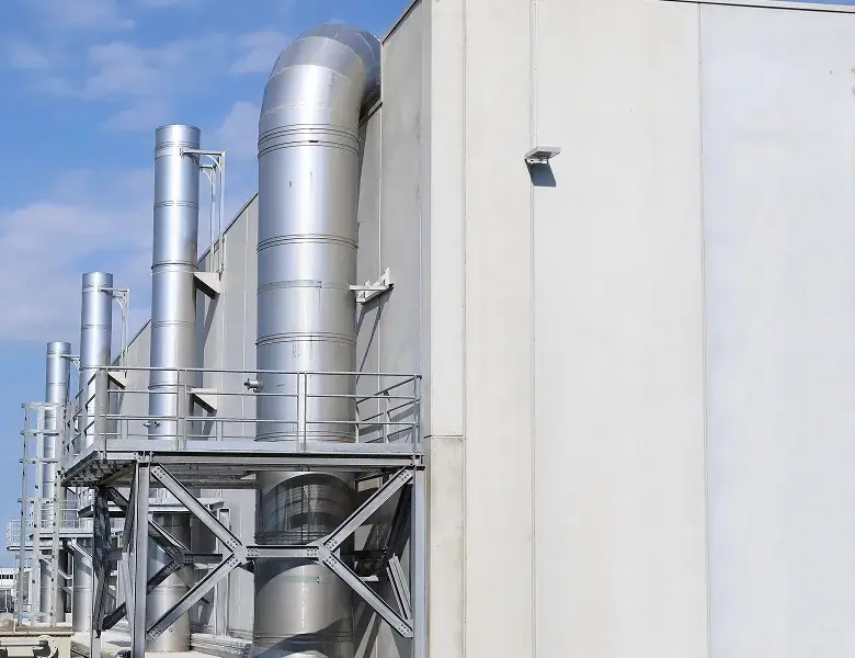 Large industrial exhaust pipes mounted on building exterior.