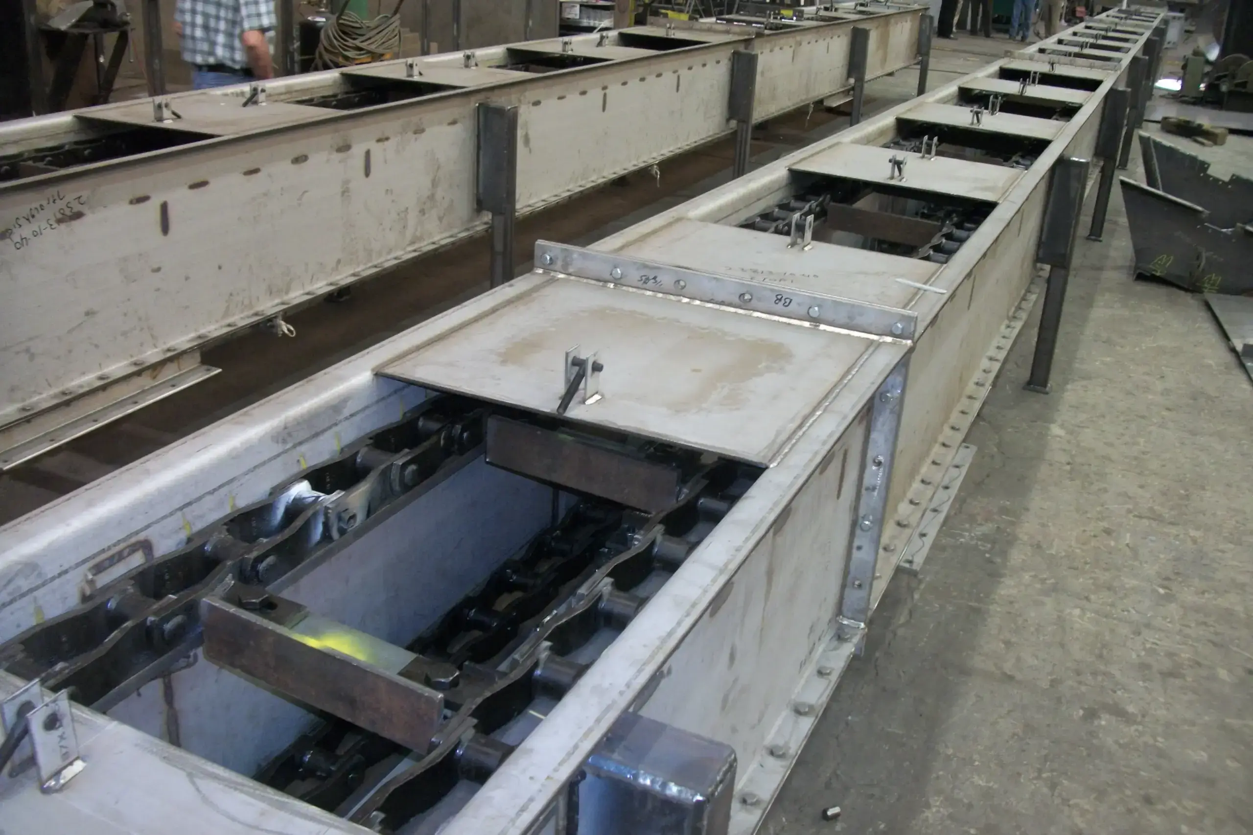 Metal conveyor system for industrial ash handling.