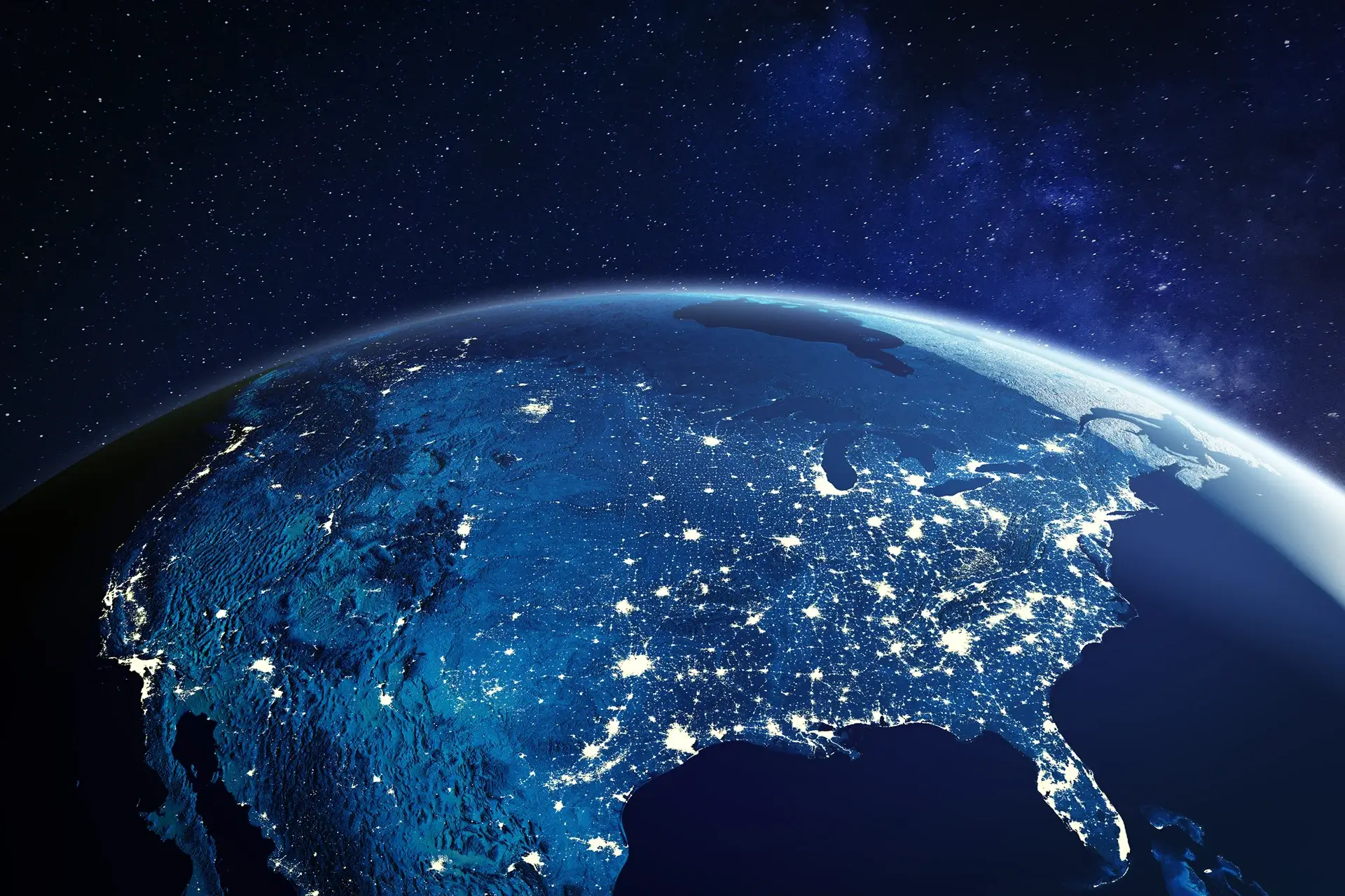 Earth from space at night with illuminated cities.