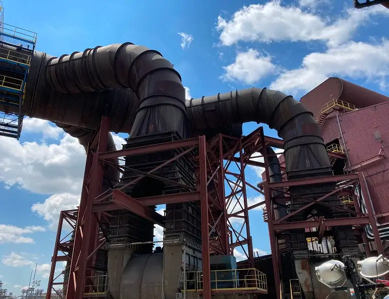 Industrial ductwork system under a bright blue sky.