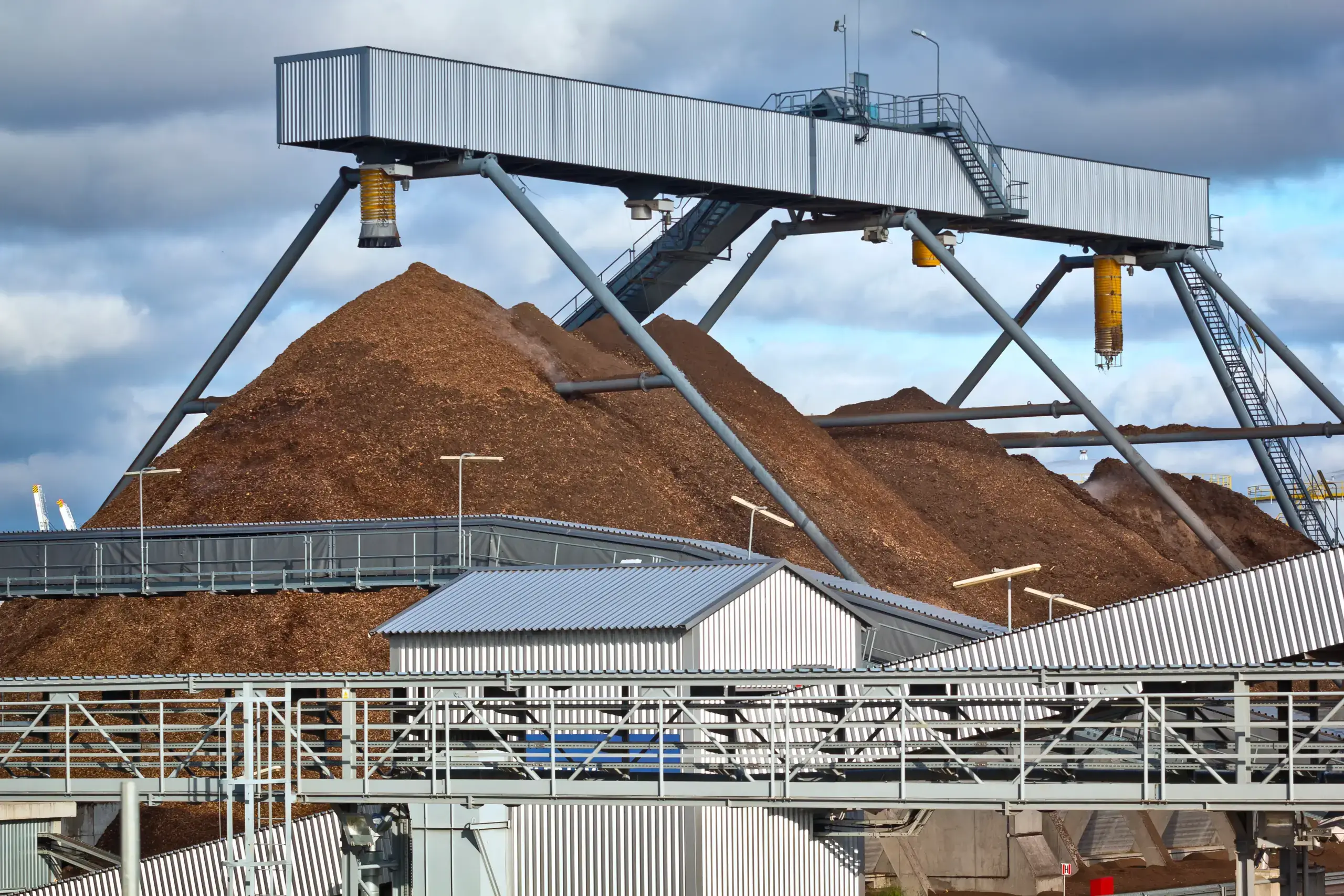 Industrial silos under a clear blue sky.