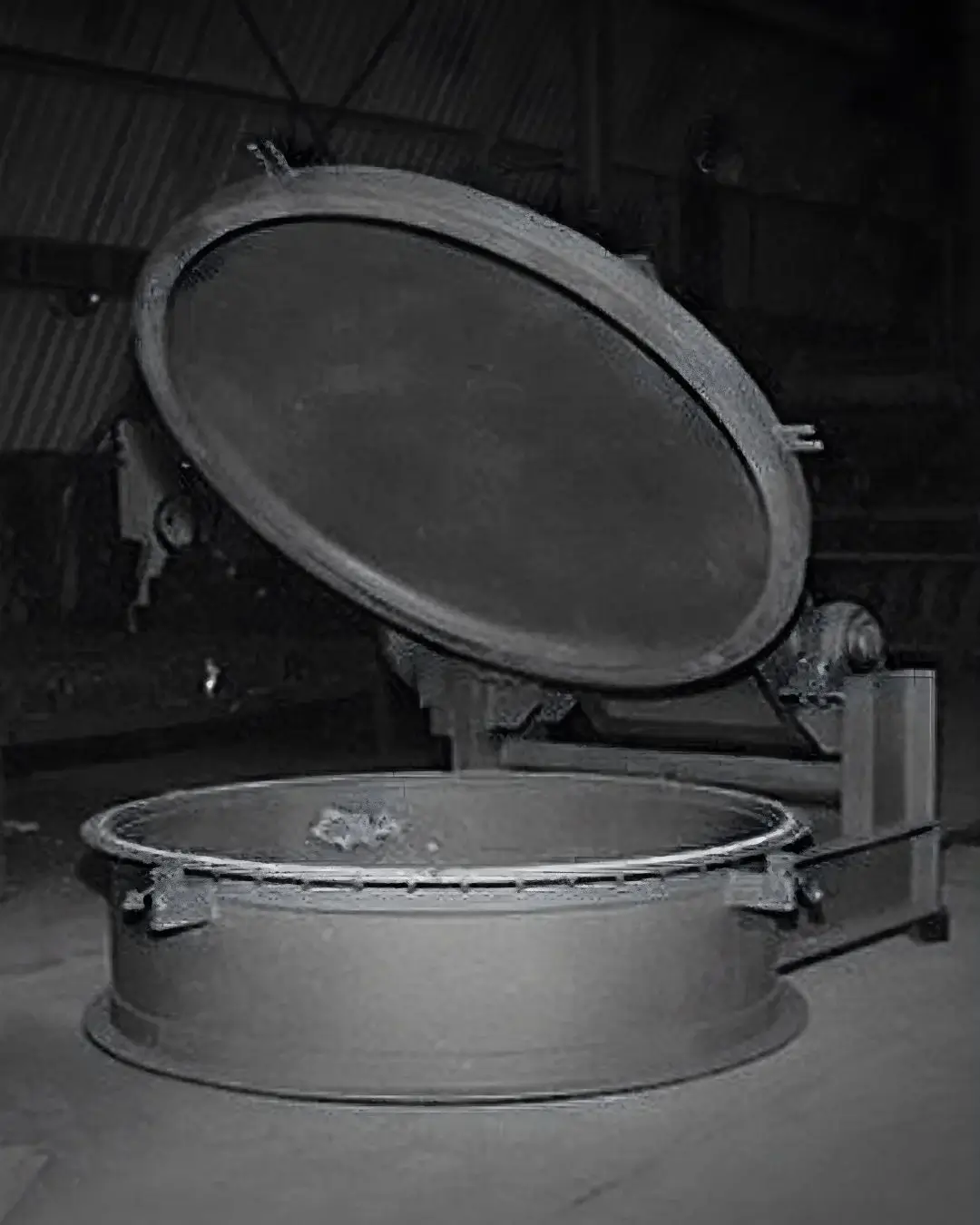 Industrial ash handling system with open drum lid.