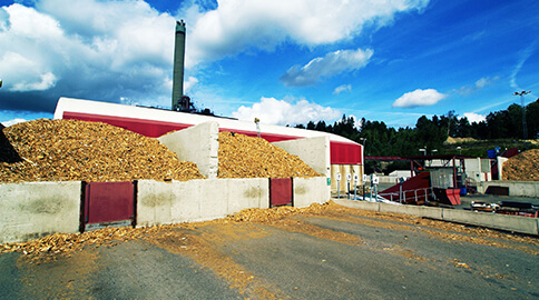 Industrial facility with large piles of wood chips.