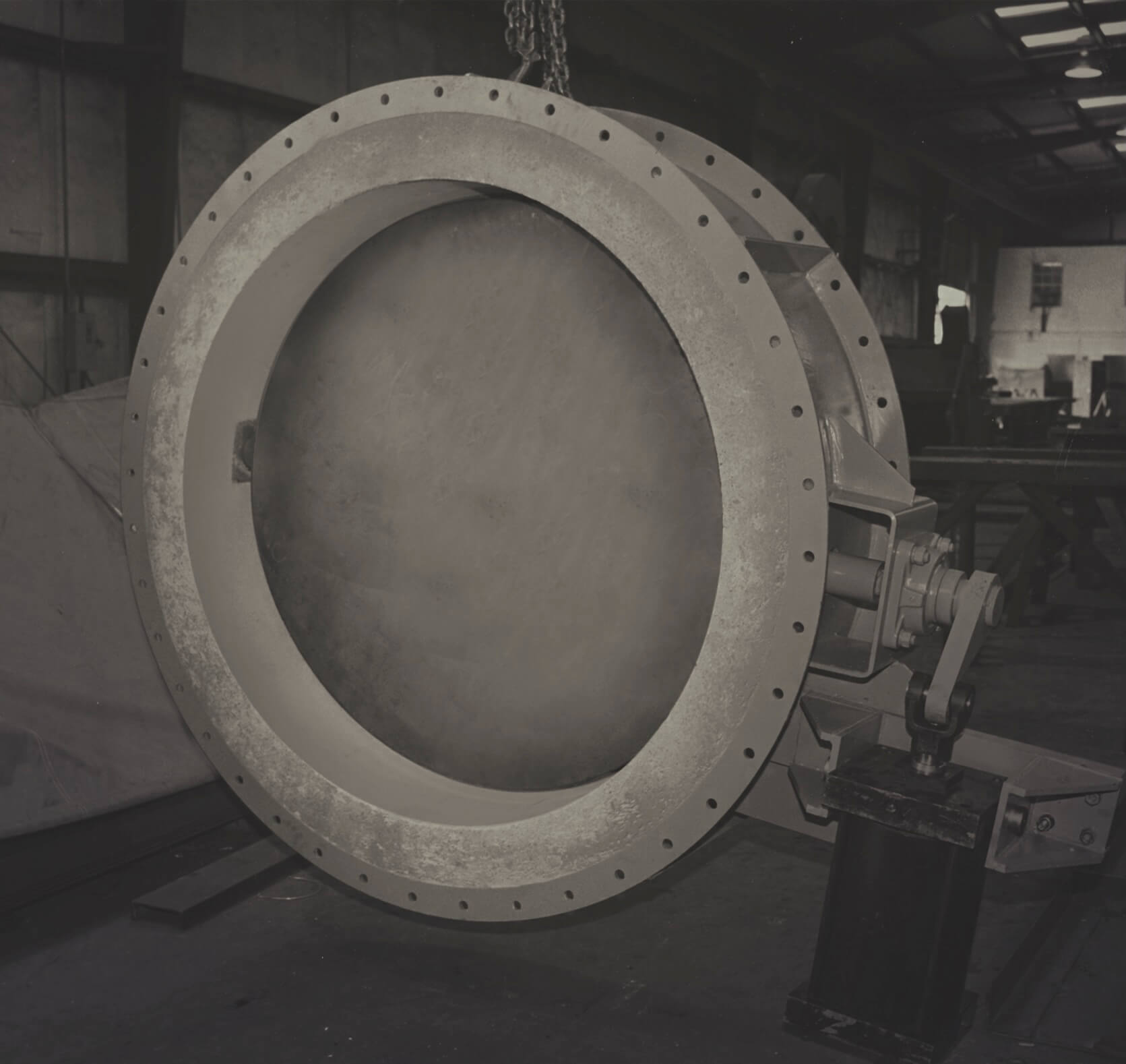 Large industrial fan in dimly lit warehouse setting.