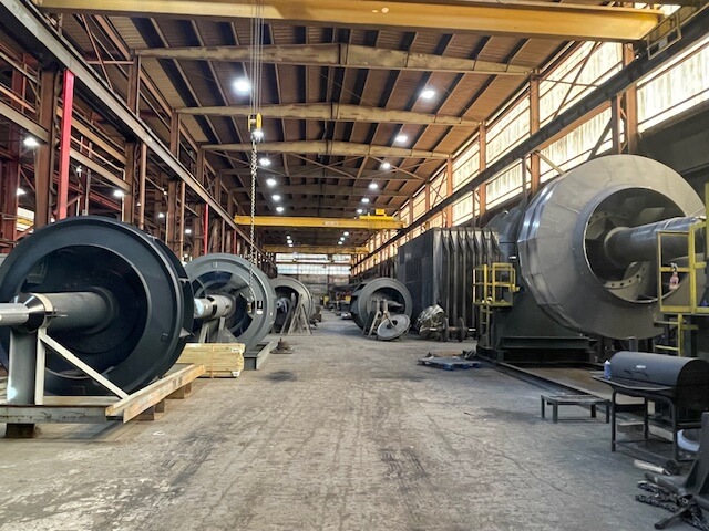 Warehouse with large industrial fans and machinery equipment.