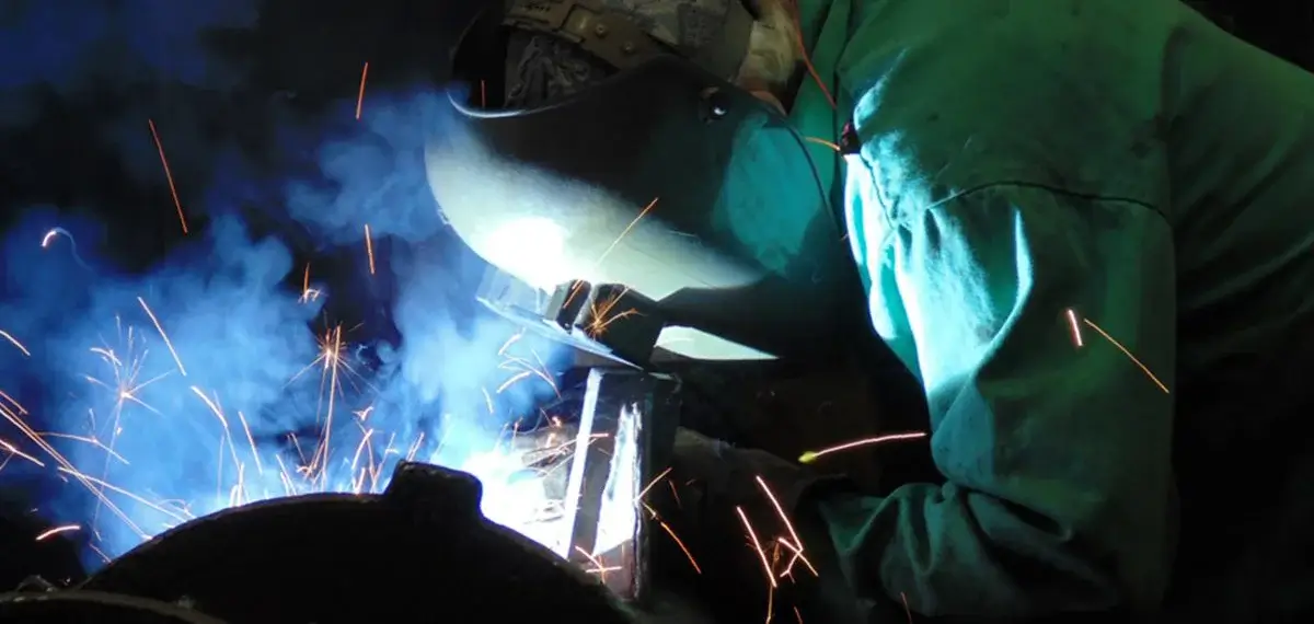 Welder creating sparks with protective gear on.
